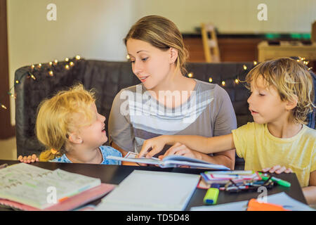 Lehrer, Tutor für heimunterricht Junge und Mädchen am Tisch. Oder die Mutter, Tochter und Sohn. Homeschooling Stockfoto