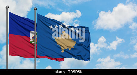 Haiti und Kosovo Flagge im Wind gegen Weiße bewölkt blauer Himmel zusammen. Diplomatie Konzept, internationale Beziehungen. Stockfoto