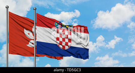 Hong Kong und Kroatien Flagge im Wind gegen Weiße bewölkt blauer Himmel zusammen. Diplomatie Konzept, internationale Beziehungen. Stockfoto