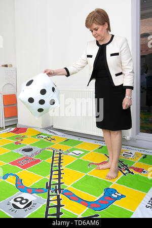 Erster Minister Nicola Sturgeon spielt eine 'snakes And Ladders' Spiel bei einem Besuch der Dundee Pflegepersonen Zentrum in Dundee. Stockfoto