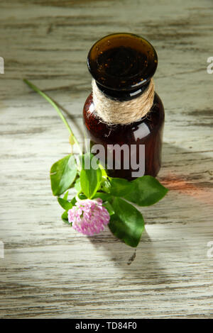 Medizin Flasche mit Klee Blume auf hölzernen Tisch Stockfoto