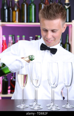 Barkeeper in Gläser gießen Champagner Stockfoto