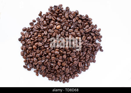 Stapel von Kaffeebohnen auf weißem Hintergrund. Schließen Sie herauf Bild. Ansicht von oben Stockfoto