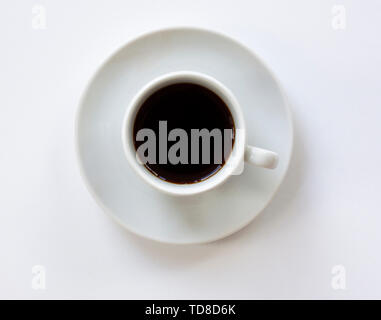 Tasse Espresso mit Untertasse auf weißem Hintergrund. Ansicht von oben. Schließen Sie herauf Bild. Stockfoto