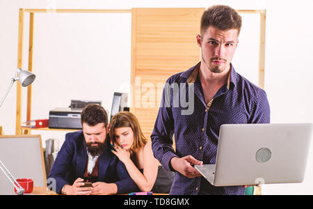 Ein erfolgreiches Unternehmen setzt auf Technologie. Business Technology. Gut aussehender Geschäftsmann mit Laptop, während Kollegen mit Smartphone mobile Technologie. Der Einsatz von Technologie in der Kommunikation mit Kunden. Stockfoto