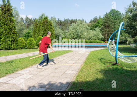 Mann spielt gorodki, beliebten alten russischen und skandinavischen folk Sport Stockfoto