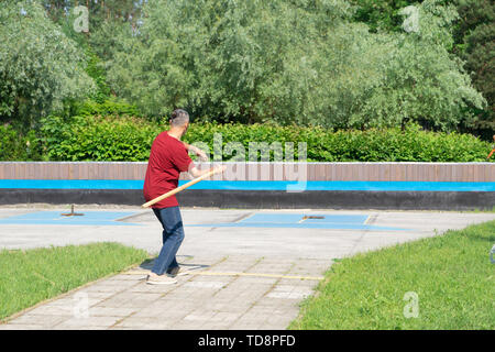 Mann spielt gorodki, beliebten alten russischen und skandinavischen folk Sport Stockfoto