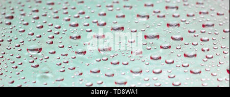 Wassertropfen auf Glas Fenster. Hellblau hinterlegt. Stockfoto