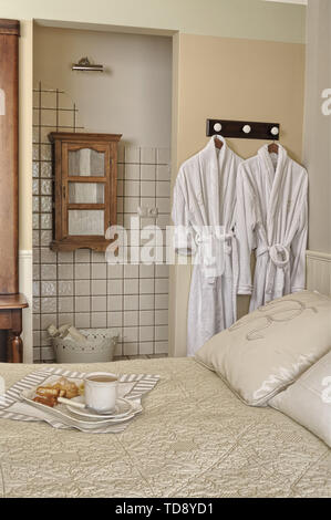 Tasse Kaffee und Kuchen auf Keramik Frühstückstablett auf komfortablen Doppelbett im Schlafzimmer Großbritannien & Irland NUR VERWENDEN Stockfoto