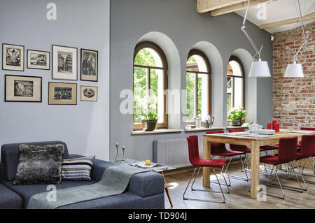 Rote Stühle am Tisch im offenen Wohnzimmer mit hoher Balkendecke und Holzböden, VK und Irland NUR VERWENDEN Stockfoto