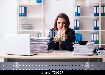 Junge schöne Mitarbeiter gebunden mit Seil im Büro Stockfoto