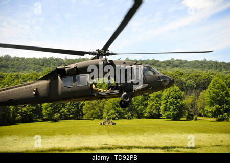 Ein UH-60 Black Hawk Hubschrauber, von Soldaten mit 28 Expeditionary Combat Aviation Brigade, fährt in Position zu schleudern, mit einem Humvee am Fort Indiantown Gap, Juni 12, 2019 geladen. Stockfoto