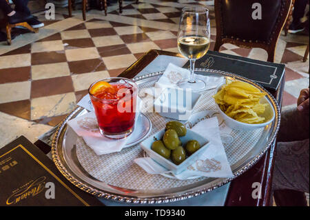 Aperol Spritz- und Weißwein mit Snacks an Caffè Florian, St. Mark's Square, San Marco, Venedig, Venetien, Italien Stockfoto