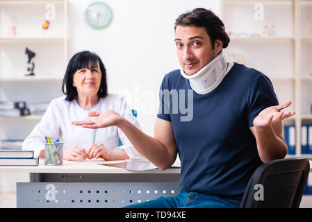 Junge männliche Patienten im Alter besuchen Ärztin Stockfoto