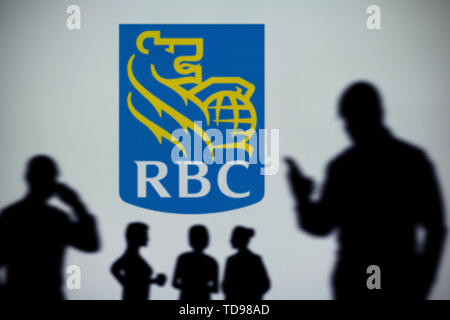 Der RBC Royal Bank Logo ist auf einen LED-Bildschirm im Hintergrund, während eine Silhouette Person ein Smartphone verwendet (nur redaktionelle Nutzung) Stockfoto