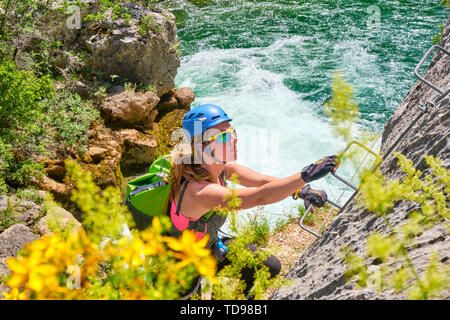 Frau Tourist, mit Klettergeräten, steigend auf die Via ferrata Route in Cikola Canyon, an einem heißen, hell, Tag Sommer, während einer geführten Tour in Kroatien. Stockfoto