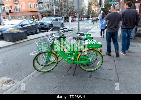 Seattle, Washington, USA / März 2019: Menschen zu Fuß Vergangenheit Kalk E Fahrräder in der Innenstadt von Seattle, WA. Stockfoto