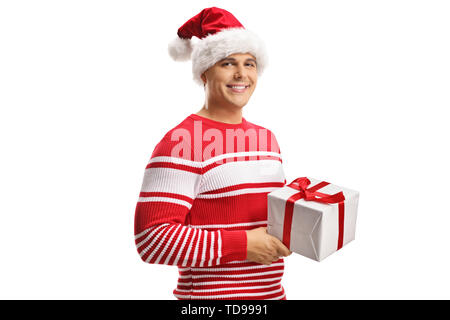 Junger Mann mit einem Weihnachtsmann Mütze und Holding a christmas gift Box auf weißem Hintergrund Stockfoto