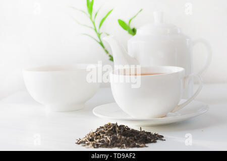 Noch immer leben Tasse grünen Tee, Teekanne mit grüner Tee trockene Blätter auf Weiß. Teatime. Stockfoto