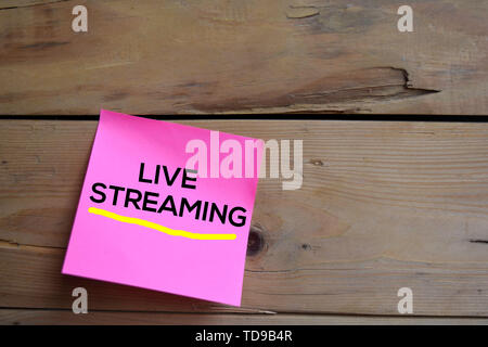 Live Streaming text auf Haftnotizen mit Holz- Hintergrund Stockfoto