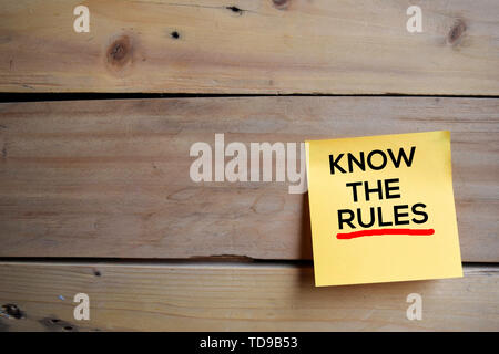 Kennen die Regeln text auf Haftnotizen mit Holz- Hintergrund Stockfoto