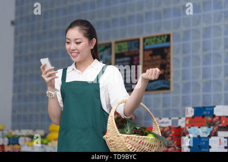 Junge hübsche chinesische Frau arbeitet in Obst speichern Stockfoto