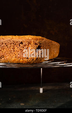 Wahre hausgemachtes Brot glutenfreie Sauerteig auf einem runden Grill auf einem dunklen Hintergrund Stockfoto