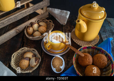 Cafe mit Milch und Gebäck auf einem alten Holztisch serviert. Stockfoto