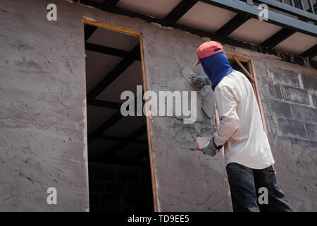 Bauarbeiter verputzarbeiten Wand mit Zementputz Stockfoto