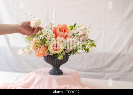 Frau Hände berühren einen Blumenstrauß. Stockfoto