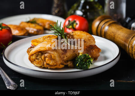 Gebratene Hähnchenkeulen mit Gemüse und Kräutern Stockfoto