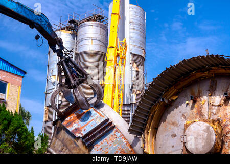 Blick auf Maschine, Lader Manipulator mit hydraulischer grappling Kralle bis sammelt, Verschieben von alten Stahl, Schrott. Stockfoto