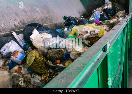 Abfallbehälter auf die Sortieranlage einer Recyclinganlage. Der Prozess der Müll trennen in einen Container. Pakete, Bügeleisen Dosen und Kunststoffflaschen Stockfoto