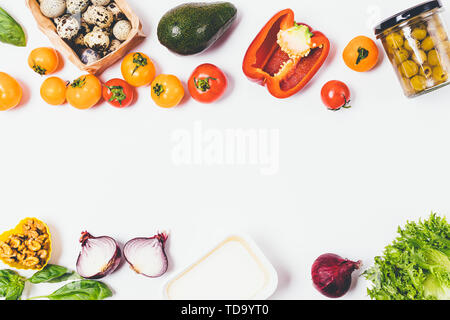 Gesundes essen Hintergrund von frischem Gemüse, Wachteleier, Käse, Salat und Grüns. Flach Anordnung Zutaten für Griechischer Salat auf weißen Tisch Stockfoto