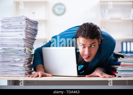 Junge männliche Mitarbeiter mit übermäßiger Arbeit unzufrieden Stockfoto