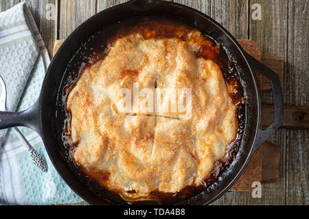 Apfelkuchen gebacken in einer gusseisernen Pfanne mit Butter Caramel Sauce und goldene Kruste Stockfoto