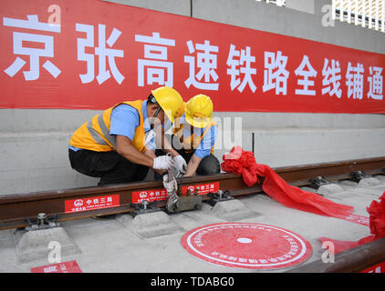 (190614) - Peking, 14. Juni 2019 (Xinhua) - konstruktoren Arbeiten auf der Spur des Beijing-Zhangjiakou High-Speed-Bahn in einem Tunnel in Peking, der Hauptstadt von China, am 12. Juni 2019. Mit dem letzten stahl schiene Stück Mittwoch in einem Tunnel der u-Bahn der Tsinghua Universität in Peking festgelegt, die den Überblick über die gesamte Länge des Beijing-Zhangjiakou High-Speed-Bahn gebaut wurde. Die ursprüngliche Eisenbahnverbindung zwischen den beiden Städten, bekannt als Chinas erste unabhängig voneinander entworfen und gebaut, wurde 1909 in Betrieb genommen. Mit einer Geschwindigkeit von 350 km pro Stunde, der 174 Kilometer lange neue Stockfoto