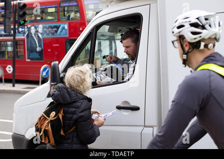 London, Großbritannien. 14 Juni, 2018. Ein Aussterben Rebellion Aktivist Hände, die Flieger zu einem LKW-Fahrer während eines Protestes gegen die Luftverschmutzung in London. Aussterben Rebellion Demonstranten blockiert London Straßen in der rush-hour Protest gegen gefährliche Luftverschmutzung in der Stadt. Credit: Ryan Ashcroft/SOPA Images/ZUMA Draht/Alamy leben Nachrichten Stockfoto