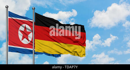 Nordkorea und Deutschland Fahne im Wind gegen Weiße bewölkt blauer Himmel zusammen. Diplomatie Konzept, internationale Beziehungen. Stockfoto