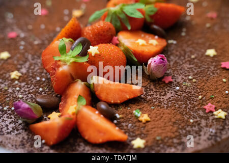 Dekoriert Trüffel Kuchen mit frischen Erdbeeren, Kaffeebohnen und kleine Rosen Stockfoto
