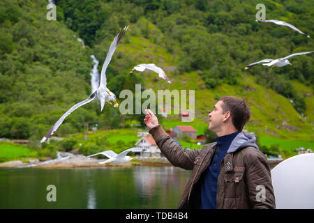 Man füttern Möwen fliegen über die Fähre Stockfoto