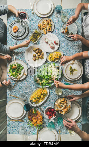 Mediterranes Abendessen und menschlichen Händen hält Getränke und Essen Stockfoto