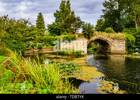 Reste der mittelalterlichen Burg Brücke, die einst unterstützt eine Straße über den Fluss Avon & jetzt eine romantische Ruine. Blick von der Mühle Garten, Warwick, Großbritannien. Stockfoto