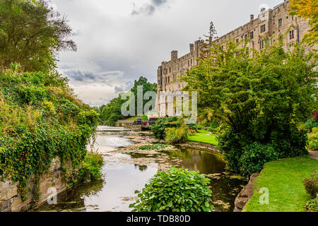 Fluss Avon aus alten Burg Brücke, gegenüber der Mühle und Süden Warwick Castle's Fassade. Warwick, Großbritannien. Sommer 2018. Stockfoto