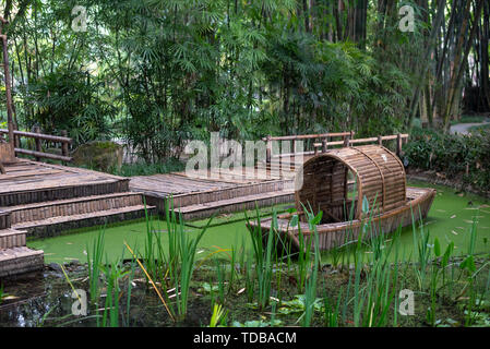 Ein kleines Holzboot im Bambuswald Behälter. Stockfoto