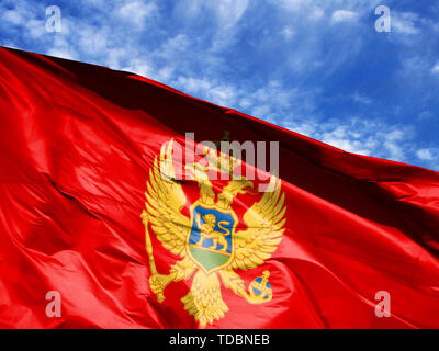 Wehende Flagge von Montenegro close up gegen den blauen Himmel Stockfoto