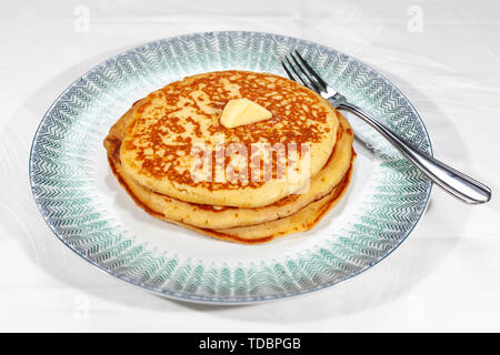 Pfannkuchen am weißen Teller Plain, Knopf von Butter und mit Sirup beträufelt Stockfoto
