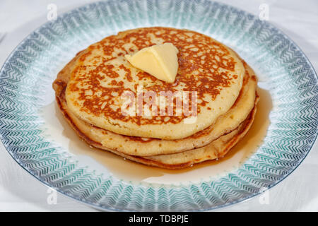 Pfannkuchen am weißen Teller Plain, Knopf von Butter und mit Sirup beträufelt Stockfoto