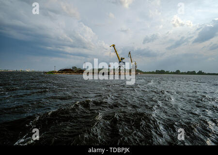 Gewitterwolken bilden über Riga Gütertransporte Hafen am Fluss Daugava am 13. Juni 2019. Riga, Lettland Stockfoto