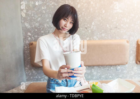 Das Mädchen, das sie eine Cola im Restaurant übergeben. Stockfoto